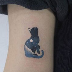 a black cat tattoo on the right side of the arm, with space in it