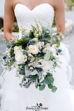 a bridal holding a bouquet of white flowers and greenery in her right hand