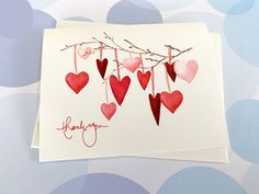 a card with hearts hanging from a branch