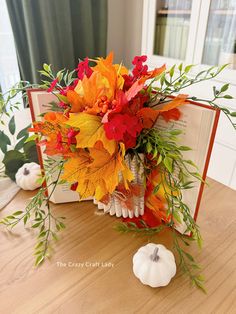 a bouquet of flowers sitting on top of a wooden table next to an open book