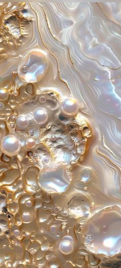 an image of bubbles in the water with gold and white swirls on it's surface