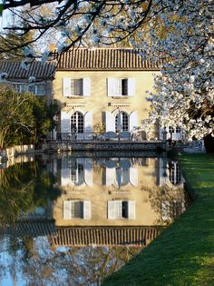 an old house is reflected in the water