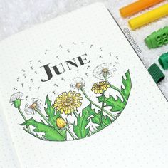 a notebook with the words june written on it next to crayons and markers