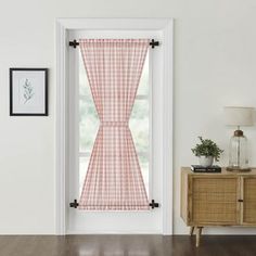 a window with a red and white checkered curtain hanging from it's side