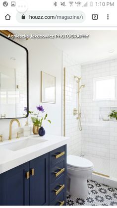 a white and blue bathroom with gold accents