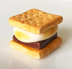 two crackers stacked on top of each other with chocolate and marshmallows