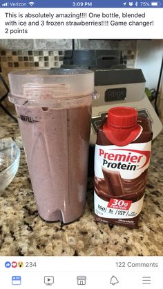 a blender sitting on top of a counter next to a carton of chocolate milk