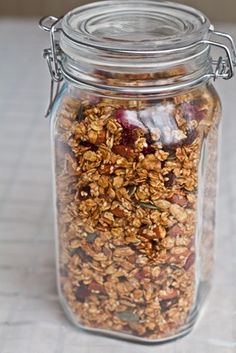 a glass jar filled with granola on top of a table