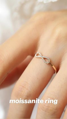 a woman's hand with a diamond ring on her finger and the words moussanite ring above it