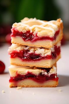 three pieces of dessert sitting next to each other on a white surface with cherries in the background