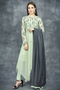 This soothing cement green three-piece suit includes a fit and flare jacket with asymmetric hemline and a subtle knot around the waist. It is paired with a solid green chiffon dupatta and a churidar to go with. Flared Jacket, Bollywood Sarees, Dresses Pakistani