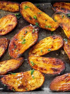 grilled potatoes with herbs and parsley on a baking sheet