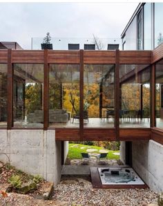 an open air hot tub in the middle of a patio area with glass walls and windows