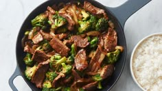 beef and broccoli stir frying in a skillet with rice on the side