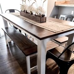 a wooden table with two benches next to it and some flowers on the bench top