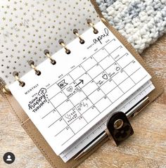 an open planner sitting on top of a wooden table