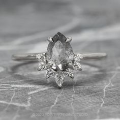 an engagement ring with two pear shaped diamonds on the top and one pear shaped diamond in the middle