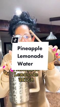 a woman holding up a sign that says pineapple lemonade water in front of her face