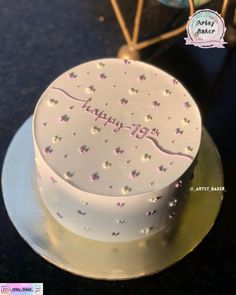 a white cake with pink frosting and stars on it sitting on top of a table