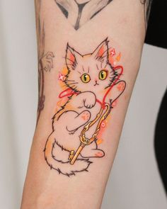 a cat tattoo on the arm with an arrow in it's paws and eyes