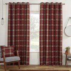 a living room with red plaid curtains and a chair