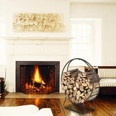 a living room with a fire place in the center and wood logs on the floor