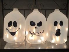 three plastic jugs with faces and lights on them