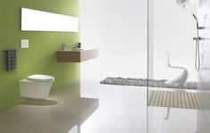 a white toilet sitting next to a green wall in a bathroom on top of a tiled floor