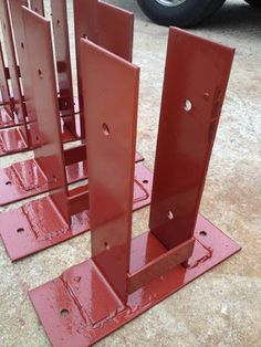 several red metal structures sitting in front of a building