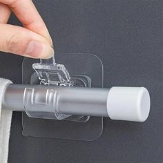 a person is holding a piece of clear plastic with a clip on it to attach something