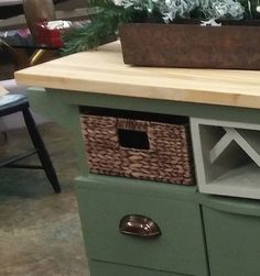 a green cabinet with baskets on top and plants growing out of the bottom drawer, in a store