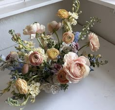 a bouquet of flowers sitting on top of a window sill