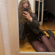 a woman sitting on the floor taking a selfie