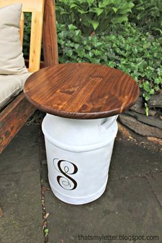 a white bucket sitting on top of a wooden bench