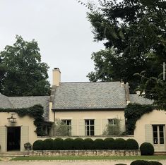 a large house with lots of windows and ivy growing on it's roof line