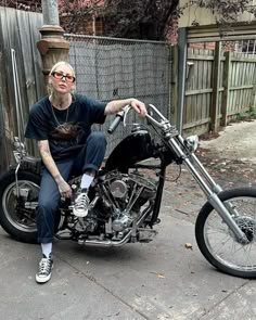 a man with tattoos sitting on a motorcycle