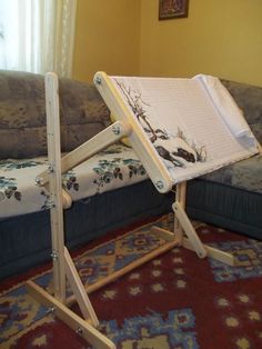 a wooden easel sitting on top of a rug next to a couch