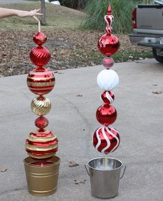 some red and gold ornaments are hanging from a line on a pole next to a bucket