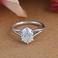 a white diamond ring sitting on top of a table