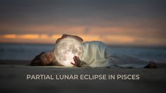 a woman laying on the beach with her hands in front of her face as she holds a light bulb