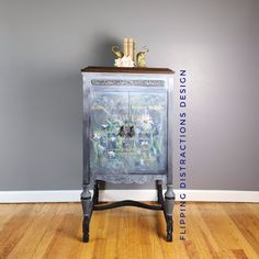 an old cabinet with flowers painted on the front and bottom is sitting on a hard wood floor