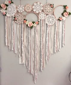 a white wall hanging with flowers and doily on the top, along with other decorations