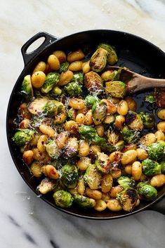 brussel sprouts and brussels sprouts in a skillet with a wooden spoon