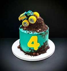 a monster truck birthday cake with dirt on the top and number four on the bottom