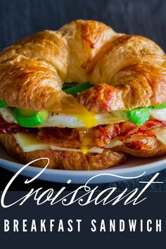 a croissant sandwich on a plate with the words breakfast sandwich written below it