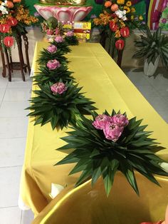 there are many flowers on the long table