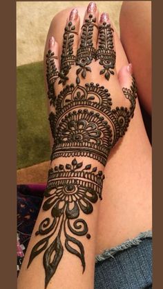 a woman's hand with henna tattoos on it