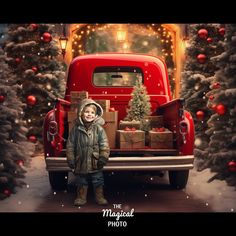 a little boy standing in front of a red truck with christmas presents on the back