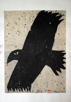 a black bird with red spots on its head is flying in the air over a white wall