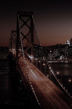 the city lights shine brightly over the bay bridge